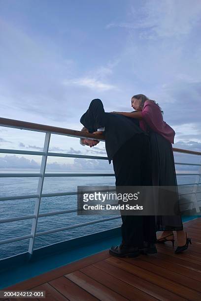 couple leaning on rail of cruise ship, at dusk - vomiting stock pictures, royalty-free photos & images