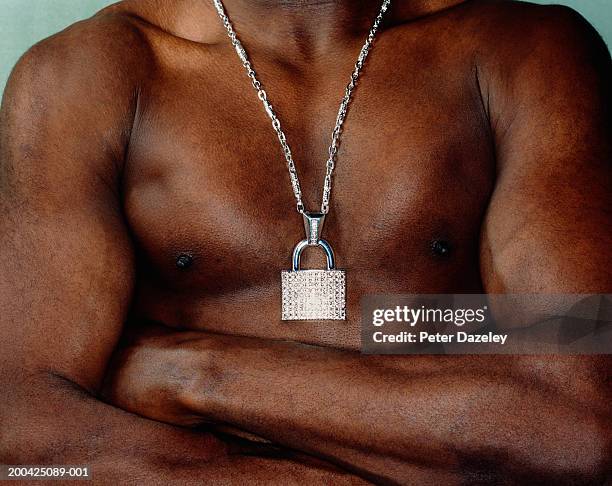 bare chested man wearing padlock around neck, arms folded, mid section - bling bling fotografías e imágenes de stock