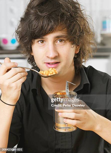 young man eating baked beans from tin, portrait - all you can eat stock pictures, royalty-free photos & images