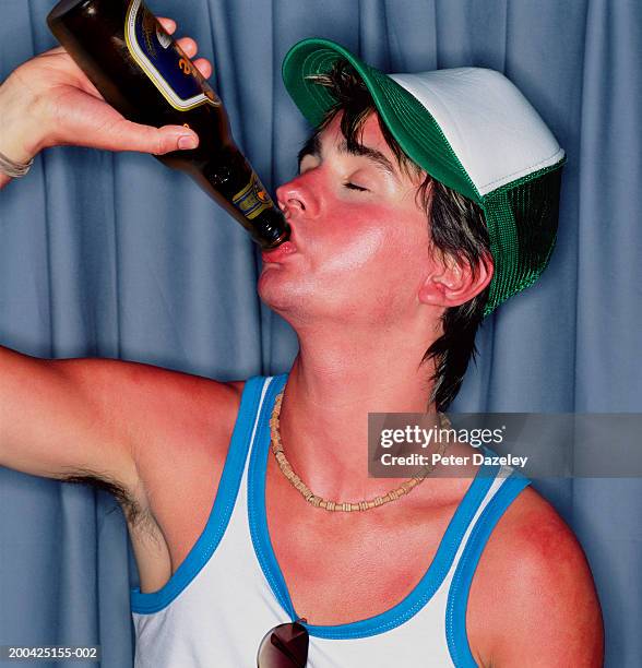 young man with sunburn, drinking bottle of beer, eyes closed, close-up - beer close up stock-fotos und bilder