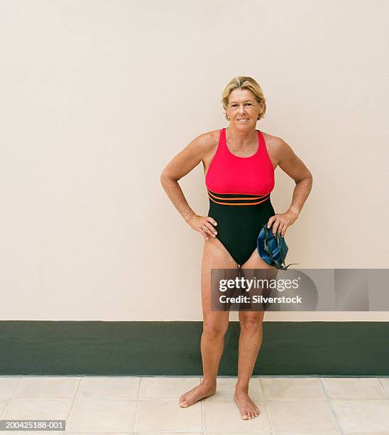 mature woman in swimming costume, holding hat and goggles, portrait - middle aged woman bathing suit stock pictures, royalty-free photos & images