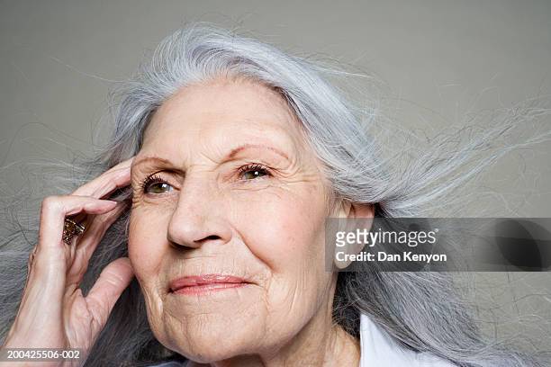 senior woman with long hair blowing away from face - mind reading stock pictures, royalty-free photos & images