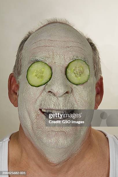 senior man wearing beauty mask and cucumber slices over eyes, smiling - men facial stock pictures, royalty-free photos & images