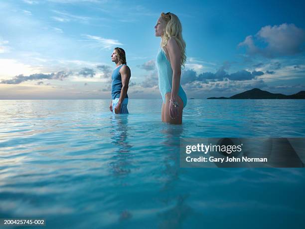 man and woman standing in sea - darkwood beach foto e immagini stock