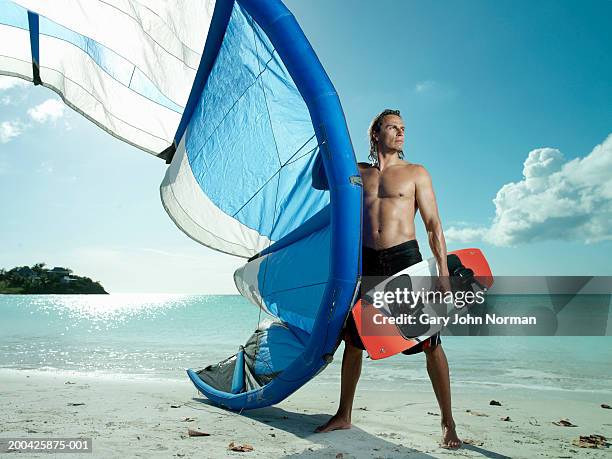 man with kite-surfing gear on beach - kite foto e immagini stock