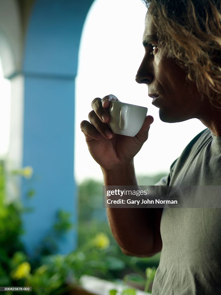 Man sipping coffee, side view