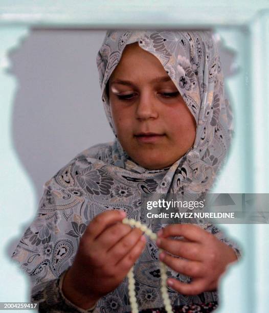 Girl belonging to Greece's muslim minority uses her prayer beads in a mosque in Komotini, northeastern Greece, 17 October 2003. Some 100,000 muslims...