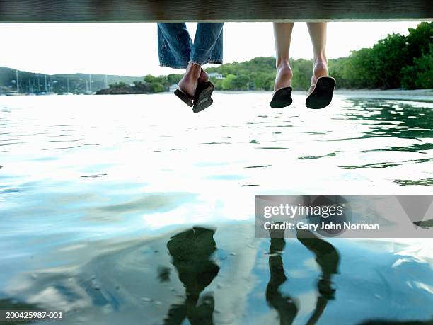 couple sitting on dock, low section, rear view - ponton photos et images de collection