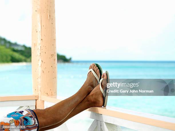 man resting feet on railing, low section, close-up - feet up - fotografias e filmes do acervo