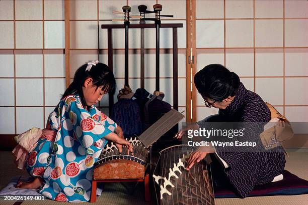 teacher giving girl (9-11) koto lesson - koto harp bildbanksfoton och bilder