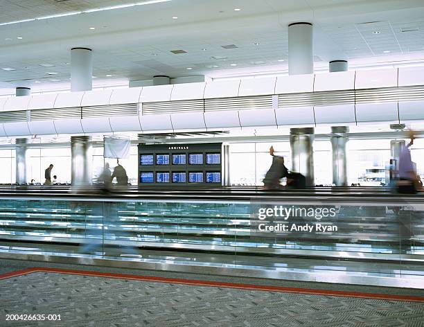 people walking on moving walkway in airport, side view (blurrd motion) - travolator stock pictures, royalty-free photos & images