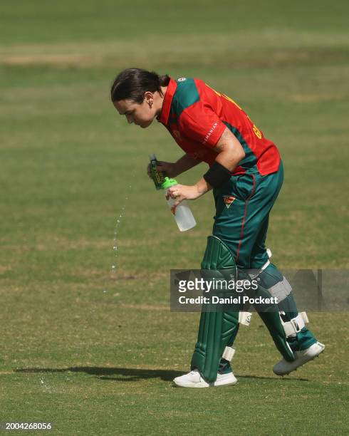 Heather Graham of Tasmania rinses her mouth after drinking pickle juice to treat cramping during the WNCL match between Victoria and Tasmania at...