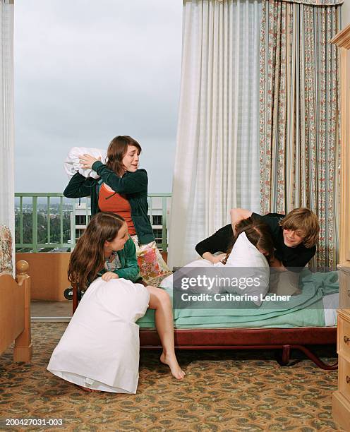 siblings having pillow fight in room - dodging stockfoto's en -beelden