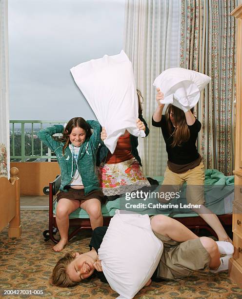 siblings having pillow fight in room - pillow fight fotografías e imágenes de stock