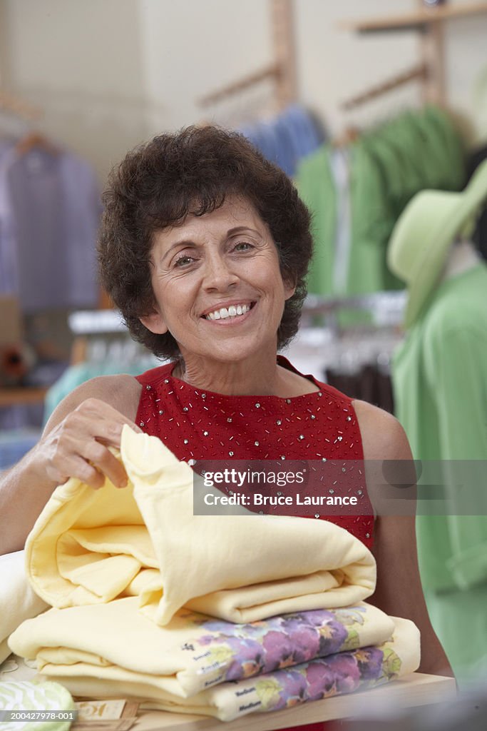 Senior woman shopping in store smiling, portrait