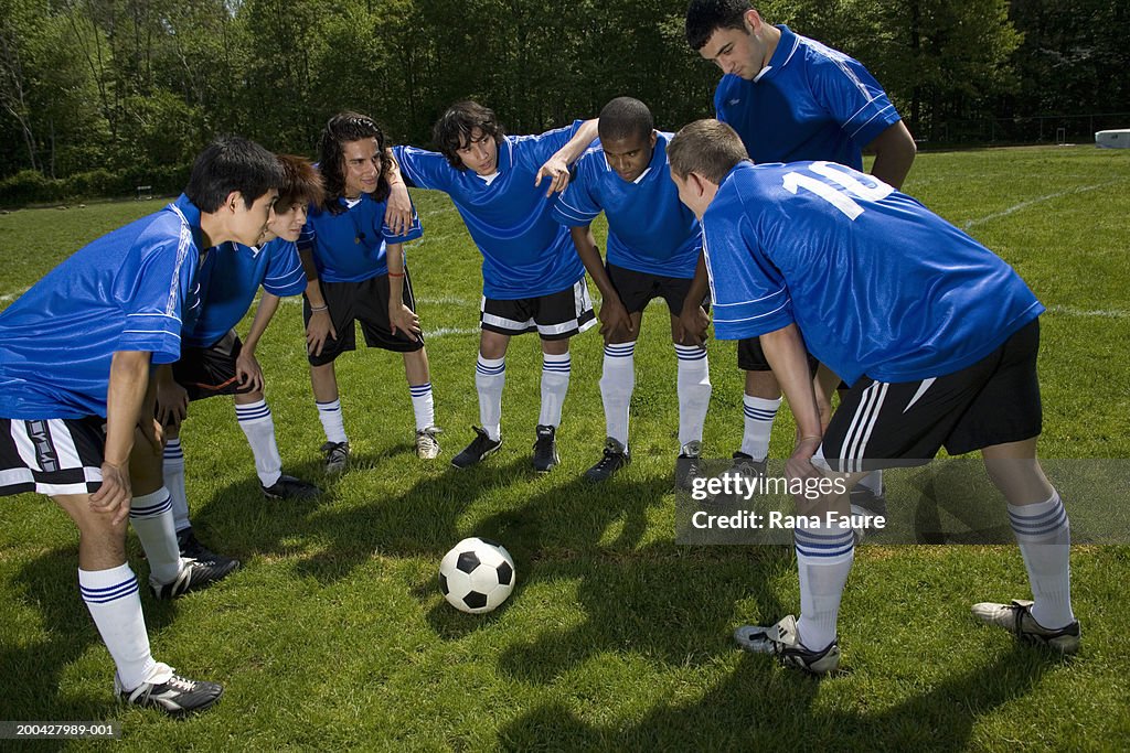 Teenage male (16-20) soccer players in huddle