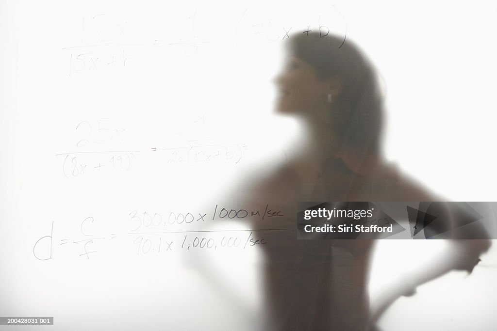 Woman standing behind frosted glass