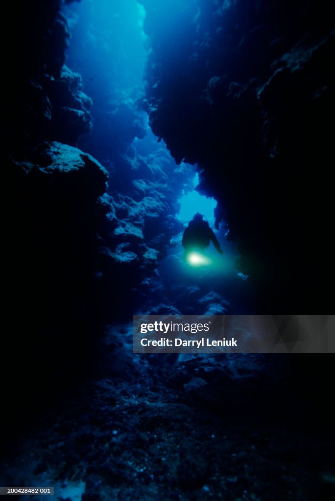 Fiji, Kadavu Island, male scuba diver in cave, underwater view