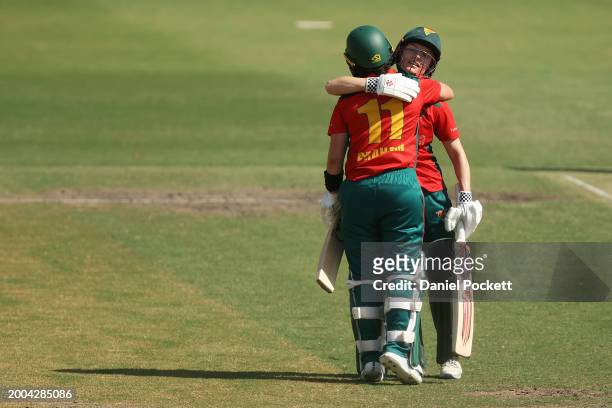 Heather Graham of Tasmania is hugged by Nicola Carey of Tasmania after making a century during the WNCL match between Victoria and Tasmania at...