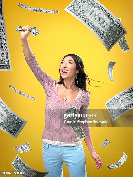 woman grabbing floating us one dollar bills (digital composite) - woman catching stock pictures, royalty-free photos & images