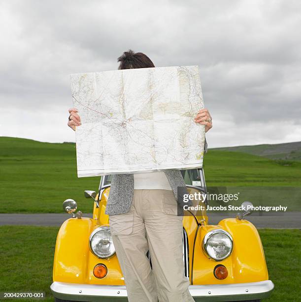 mature woman looking at map - stock photo car chrome bumper stock-fotos und bilder