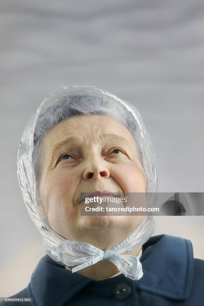 Senior woman wearing plastic rain hat