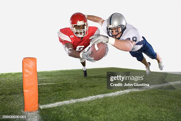 two american football players diving with ball (digital composition) - american football player catch stock pictures, royalty-free photos & images