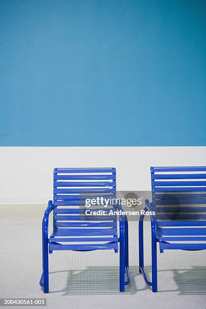 two deck chairs on tiled floor - silla de playa fotografías e imágenes de stock