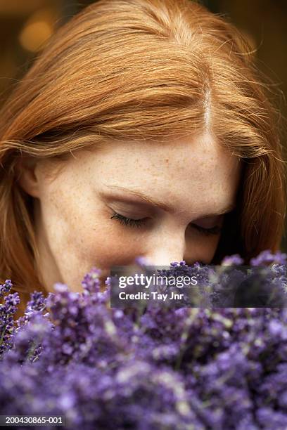 young woman smelling lavendar, eyes closed, close-up - ruiken stockfoto's en -beelden