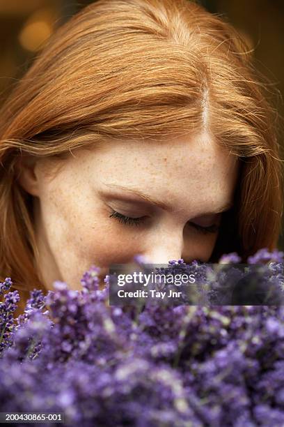 young woman smelling lavendar, eyes closed, close-up - lavendel plant stockfoto's en -beelden