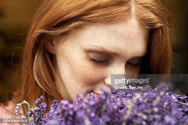 young woman smelling lavendar, eyes closed, close-up - sensory perception stock pictures, royalty-free photos & images