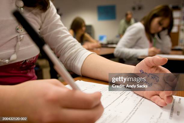 teenage girl (15-17) cheating on math test (focus on formula on hand) - examinations imagens e fotografias de stock