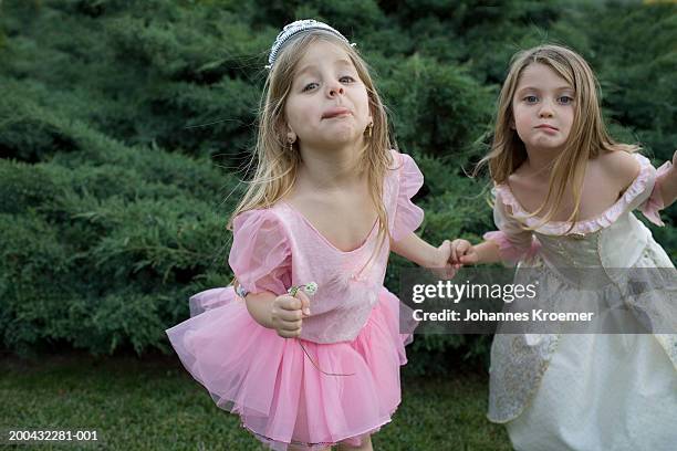 two girls (4-6) in costumes making faces in backyard, portrait - mädchen frech stock-fotos und bilder