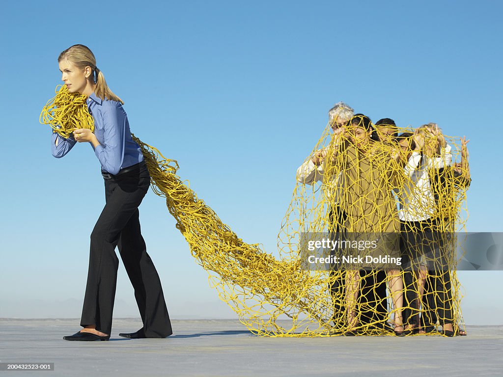 Business woman catching group of business people in net