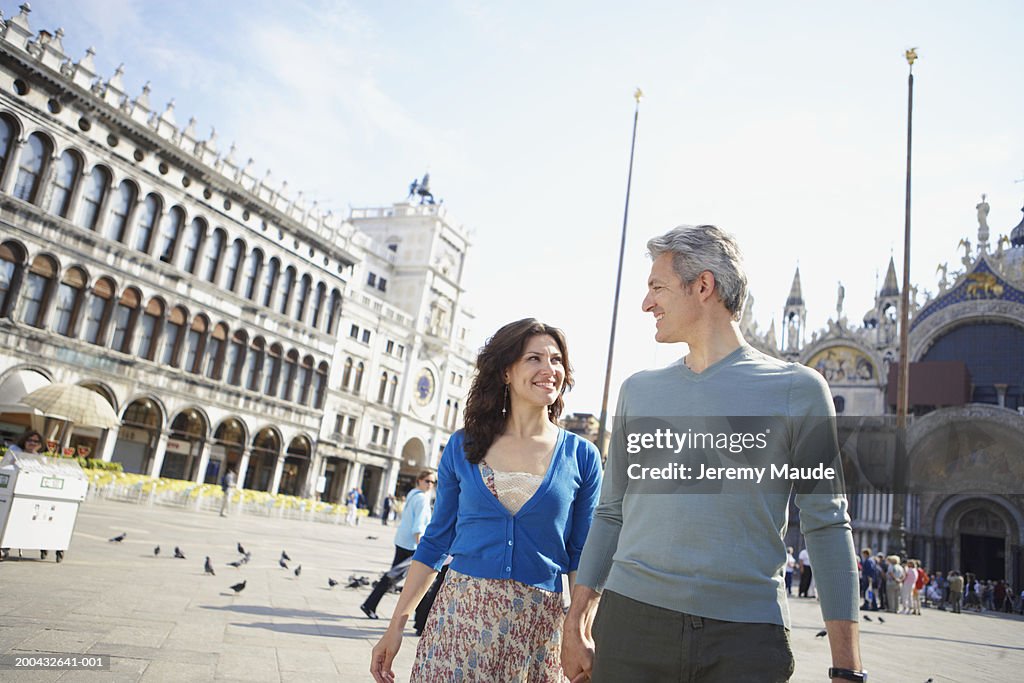 Italy, Venice, couple walking through St Mark's Square, holding hands