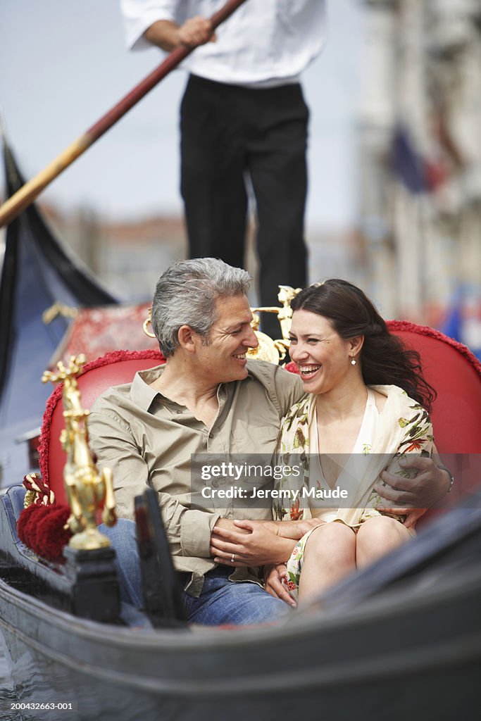 Italy, Venice, couple in gondola, man's arm around woman