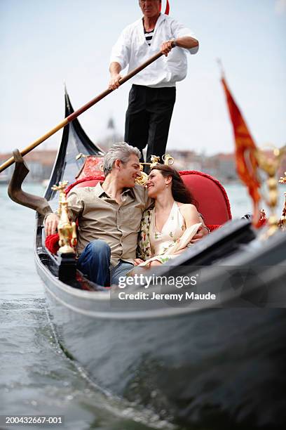 italy, venice, couple in gondola, smiling at each other - gondel stock-fotos und bilder