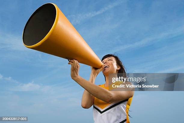 female cheerleader shouting into megaphone - asian cheerleaders stock-fotos und bilder