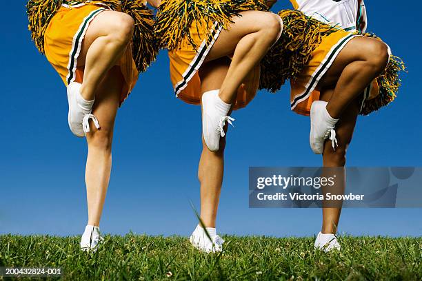 female cheerleader's legs (low section) - cheerleader stock pictures, royalty-free photos & images