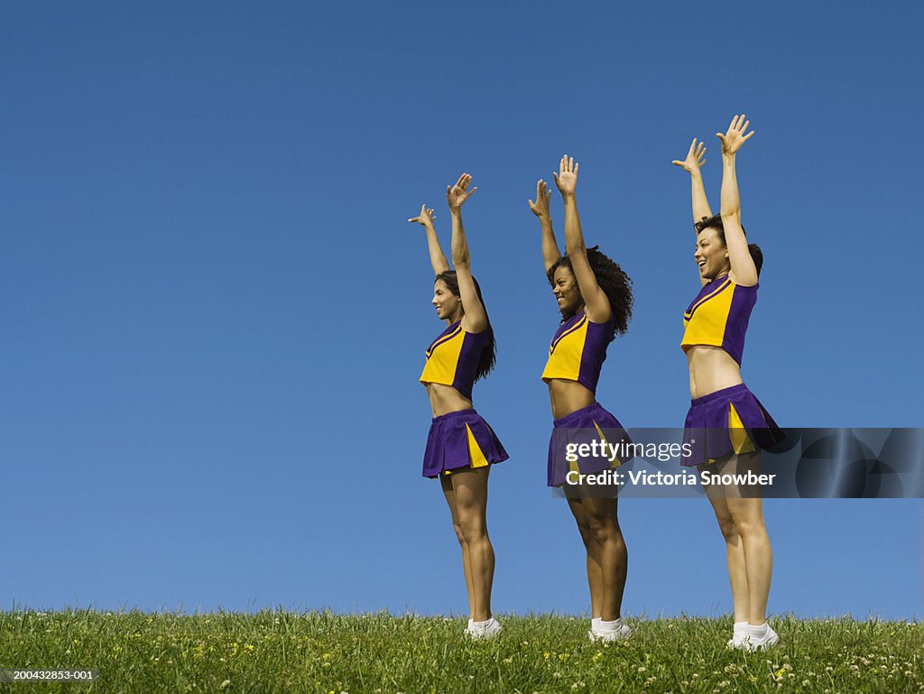 Three female cheerleaders standing in row
