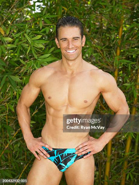 young man in racing briefs standing with hands on hips, portrait - young men in speedos 個照片及圖片檔