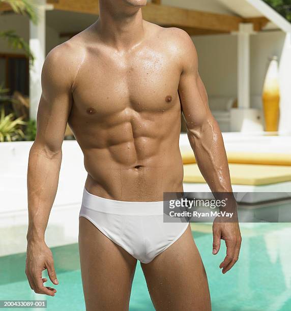young man in racing briefs standing beside pool, mid section - young men in speedos �個照片及圖片檔
