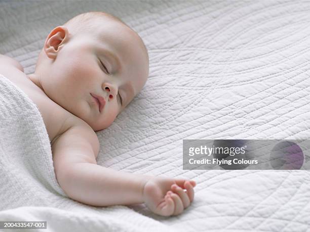 baby girl (6-9 months) sleeping under blanket, close-up - baby close up bed stockfoto's en -beelden