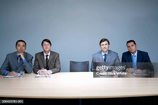 four businessmen sitting next to empty chair in boardroom, portrait - four bussines man at office imagens e fotografias de stock