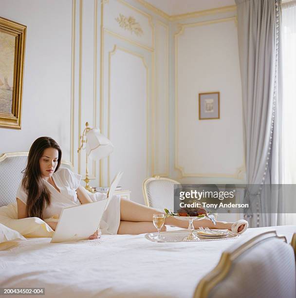 young woman laying on bed, reading - premium paris stock pictures, royalty-free photos & images