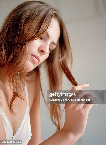 young woman looking at hair, close up - examining hair stock pictures, royalty-free photos & images