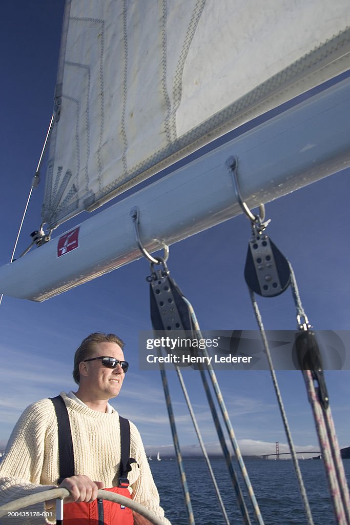Mature man steering sailboat