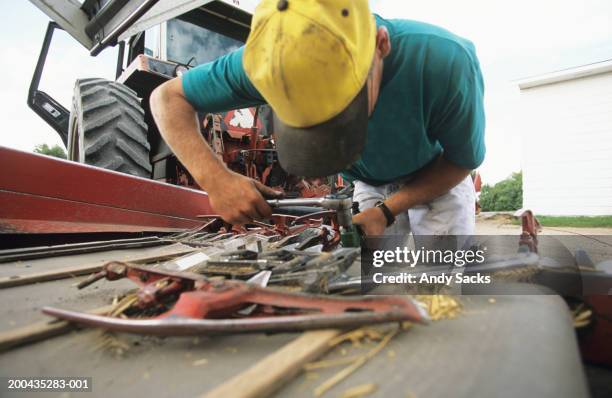 man repairing farm implement - agricultural equipment bildbanksfoton och bilder