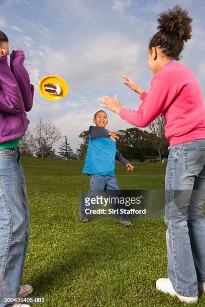 boy (7-9) throwing paper plate with cake at two girls - throwing cake stock pictures, royalty-free photos & images