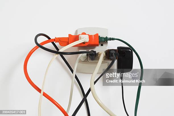 power cords in outlet - enchufes fotografías e imágenes de stock